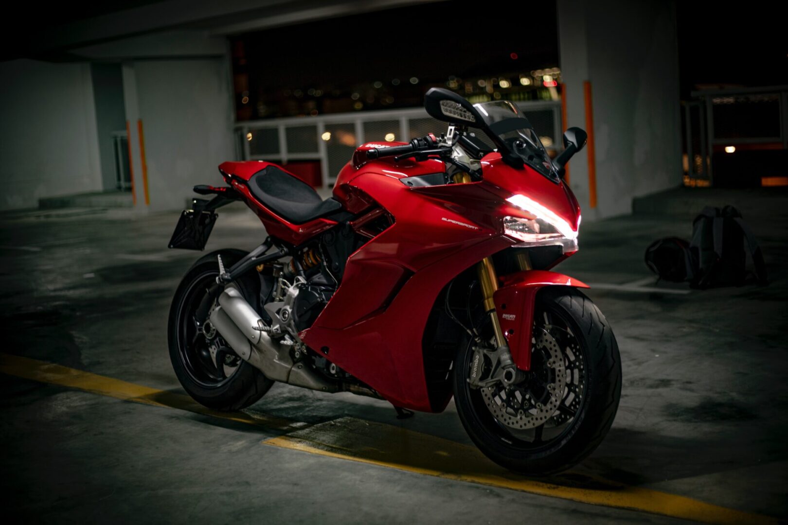 A red motorcycle parked in a parking garage.